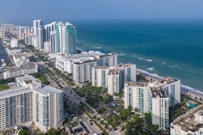 Eine Küstenstadt mit Hochhäusern, einem Strand und blauem Himmel.