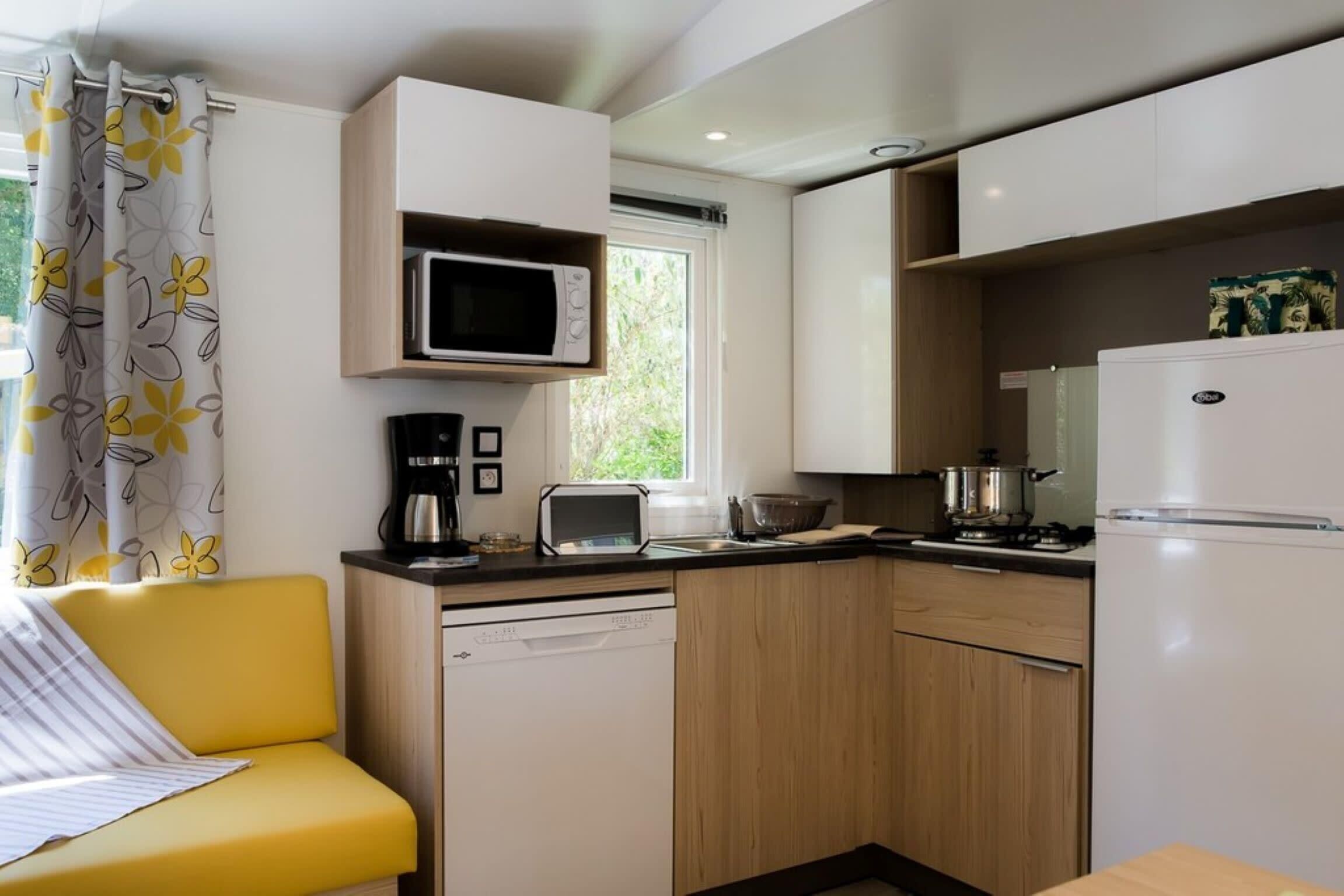 Cozinha compacta com micro-ondas, torradeira e frigorífico.