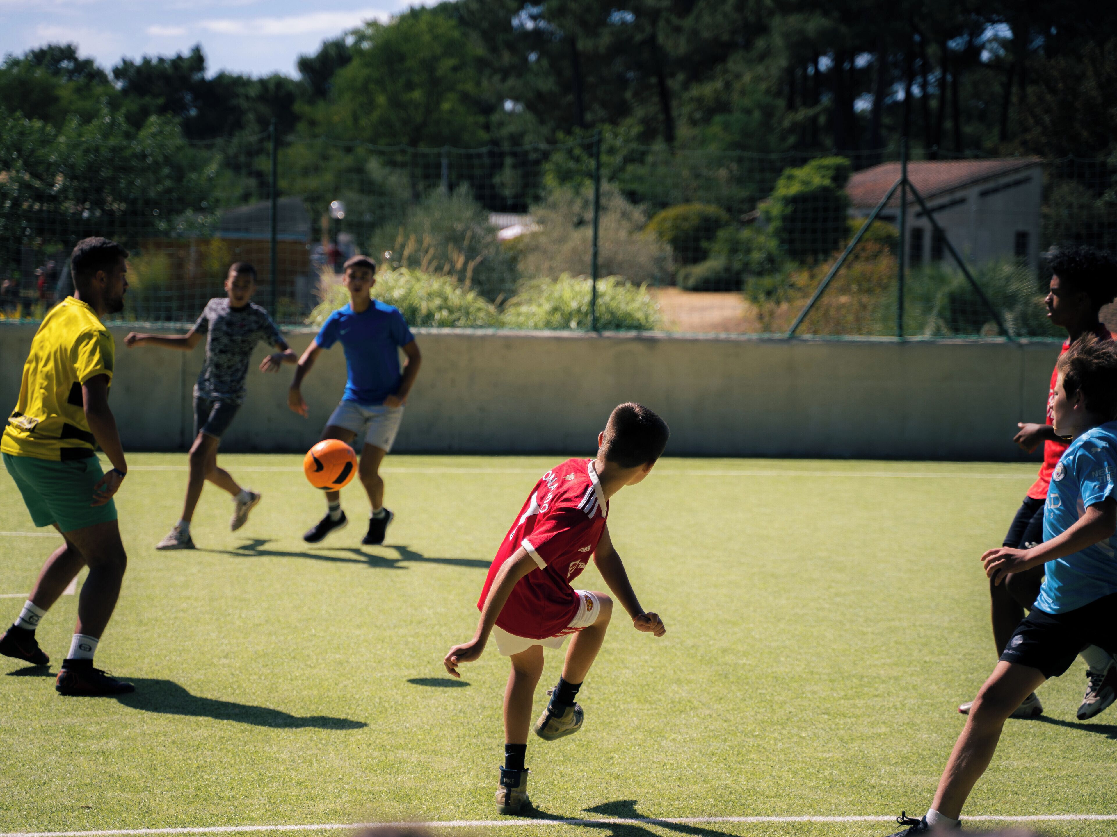 A group of people playing soccer on a grassy field.