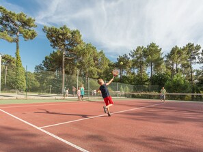 A tennis court with a net, surrounded by trees and a fence. - Palmyre - Eco-lodge 2 - 4p (2) (Les Mathes)