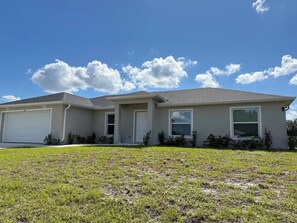 A single-story house with a garage, a front porch, and a well-maintained lawn.