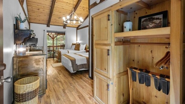 Un interior rústico de madera con una cama, un comedor y una cocina.