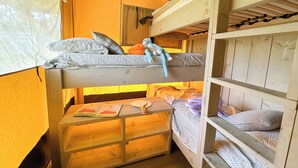 Habitación con literas, un escritorio de madera y una ventana con cortinas.