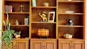 A wooden bookcase with multiple shelves, some containing books and decorative items. - Peaceful Apartment in Sucre, steps from the Downtown (Sucre)