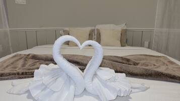 Un letto con un asciugamano disposto a forma di cuore e una coperta marrone.