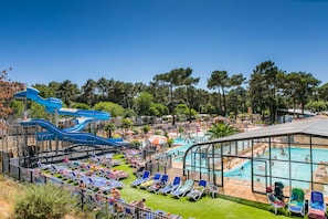 Ett semesterhotell med en vattenpark, ett poolområde och solstolar.