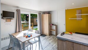 Una cucina moderna con zona pranzo, televisore a parete e vista sull'esterno.