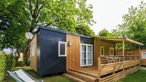 A small, modern cabin with a wooden deck and a covered seating area. - Bréhadour - Privilège 3 - 6p (3) (Guérande)