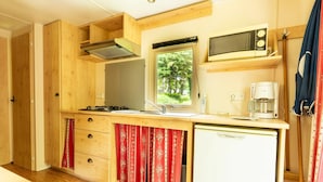 Une cuisine compacte équipée d’un four à micro-ondes, d’une cuisinière et d’un réfrigérateur.
