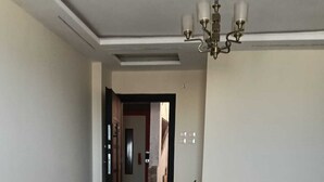 A living room with a wooden coffee table, two decorative vases, a chandelier, and a patterned rug. - Apartment of Life pyramids View (Giza Governorate)