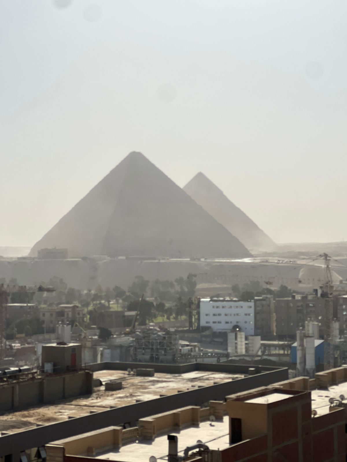 A cityscape with two pyramids in the background.