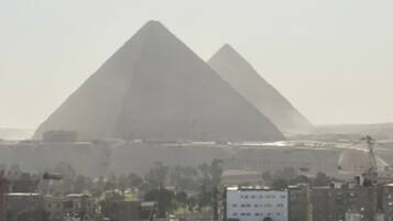 A cityscape with two pyramids in the background.