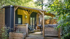 A wooden cabin with a covered patio, outdoor seating, and a small garden area. - Truffe - Privilège 3 - 6p (Saint-Geniès)