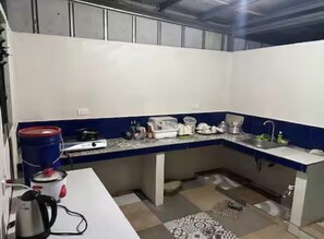 Een kookplaat, een vaatwasser, kookgerei, borden en bestek