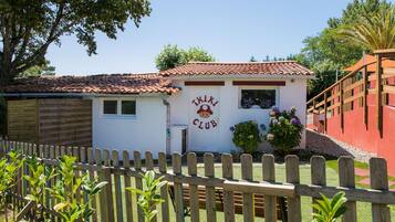 A small building with a sign that reads "TIKI CLUB" and a wooden fence in the foreground.
