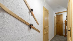 Ein Flur mit weißen, strukturierten Wänden, Holztüren und einem Holzschrank.