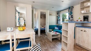Ett kompakt bostadsutrymme med ett litet kök, en matplats och en soffa.