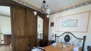 Une chambre à coucher avec un lit, une armoire en bois et un ventilateur de plafond.