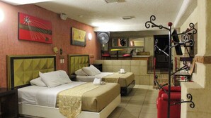 A hotel room with two beds, a red chair, a fan, and a kitchenette. - Habitación Doble Hotel Boutique Azul Turquesa (Cuernavaca)