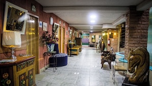 A hallway with a wooden cabinet, a blue ottoman, and a horse statue. - Habitación Doble Hotel Boutique Azul Turquesa (Cuernavaca)