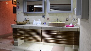A bathroom with two mirrors, a sink, and a vanity with a basket and toiletries. - Habitación Doble Hotel Boutique Azul Turquesa (Cuernavaca)