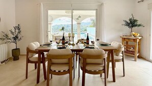 A dining area with a table set for six, a potted plant, and a view of the outdoors. - Finca Moderna w/Private Pool & Views/Tolox (Tolox)