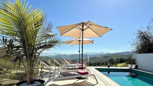 A poolside area with lounge chairs, umbrellas, and a view of mountains. - Finca Moderna w/Private Pool & Views/Tolox (Tolox)