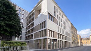 Ein modernes, mehrgeschossiges Gebäude mit flachem Dach, großen Fenstern und einem verschlossenen Eingang.