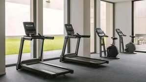 Ein Fitnessraum mit Laufbändern und einem Crosstrainer.