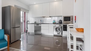 Una cocina moderna con electrodomésticos de acero inoxidable, lavavajillas y lavadora.