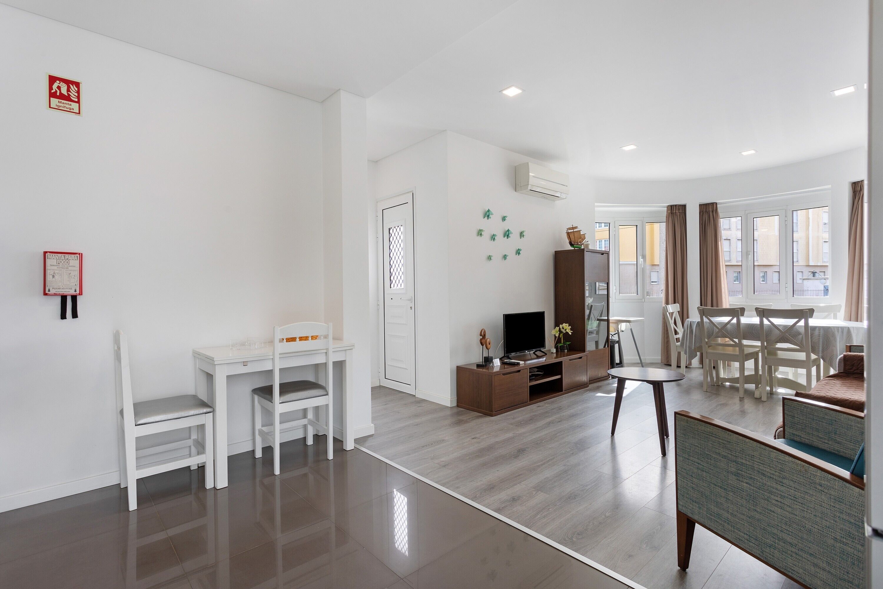 A modern living room with a TV, seating, and a dining area.
