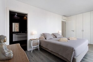 A bedroom with a bed, bedside tables, a nightstand, a wall-mounted TV, and a wardrobe. - Apartment 'Casa Dos Terraços Penthouse' with Balcony, Wi-Fi and Air Conditioning (São Martinho do Porto)