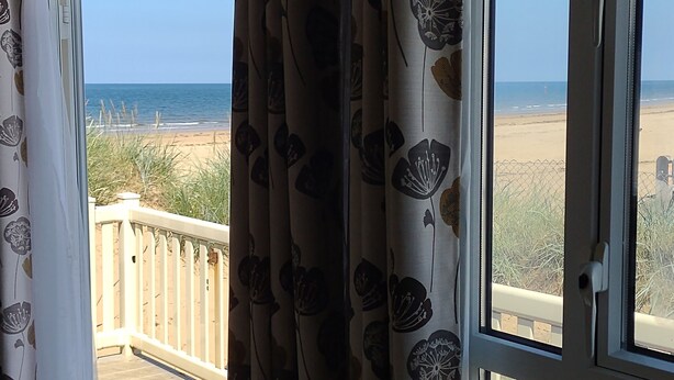 Un balcón con vista a la playa y al océano.