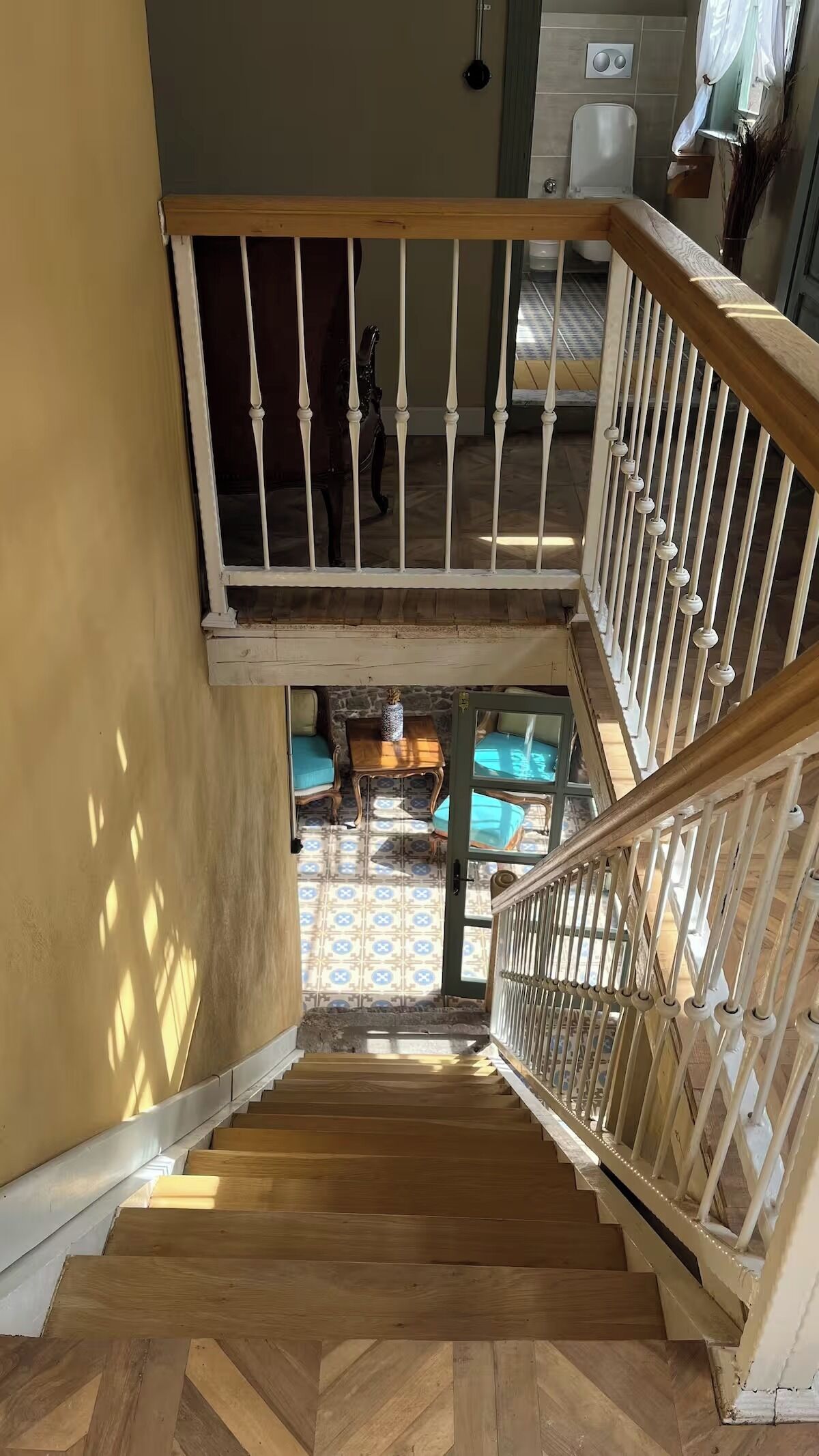 A wooden staircase with white balusters leading to a lower level.