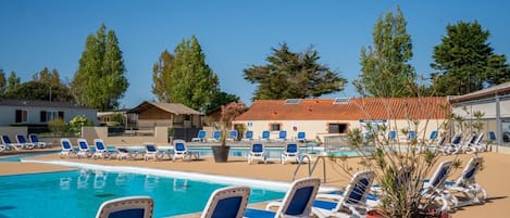 Un espace piscine avec des chaises longues et une plante en pot.