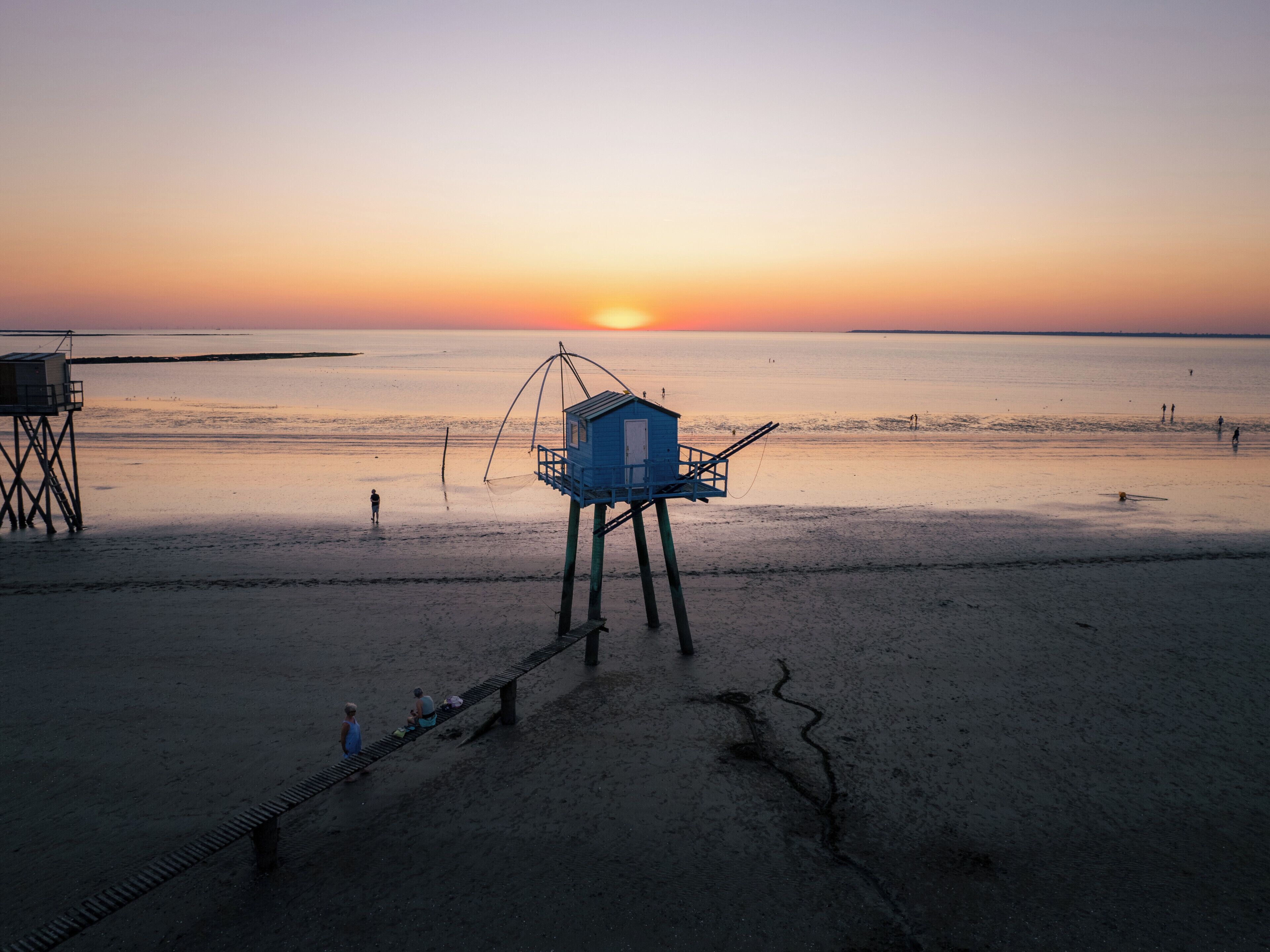 Ein Strand mit einem Rettungsturm und einem hölzernen Steg.