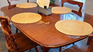A wooden dining table with four chairs, a centerpiece with a basket, and a plant in the background. - Cozy 1-bedroom lake front cabin in the quaint town of Keystone Heights, FL (Keystone Heights)