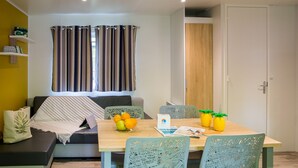 Un comedor con una mesa de madera, sillas y un bol de fruta.