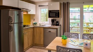 Una cocina moderna con electrodomésticos de acero inoxidable, armarios de madera y vistas al patio exterior.