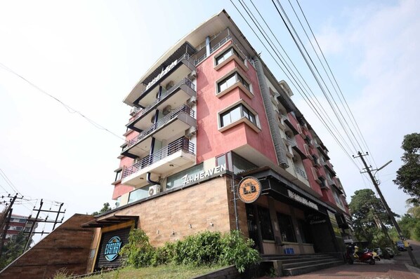 A multi-story building with balconies, a sign for 'Zar Haven', and a 'L B' logo. - 7th Heaven Hotel Apartments (Manipal)