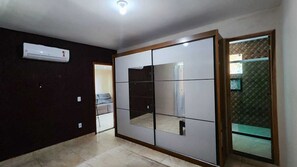 Ein Zimmer mit einer Schiebetür, einer Deckenleuchte und einem Fliesenboden.