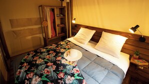 Ein Schlafzimmer mit einem Bett, einem Nachttisch, einer Lampe und einem Kleiderschrank.