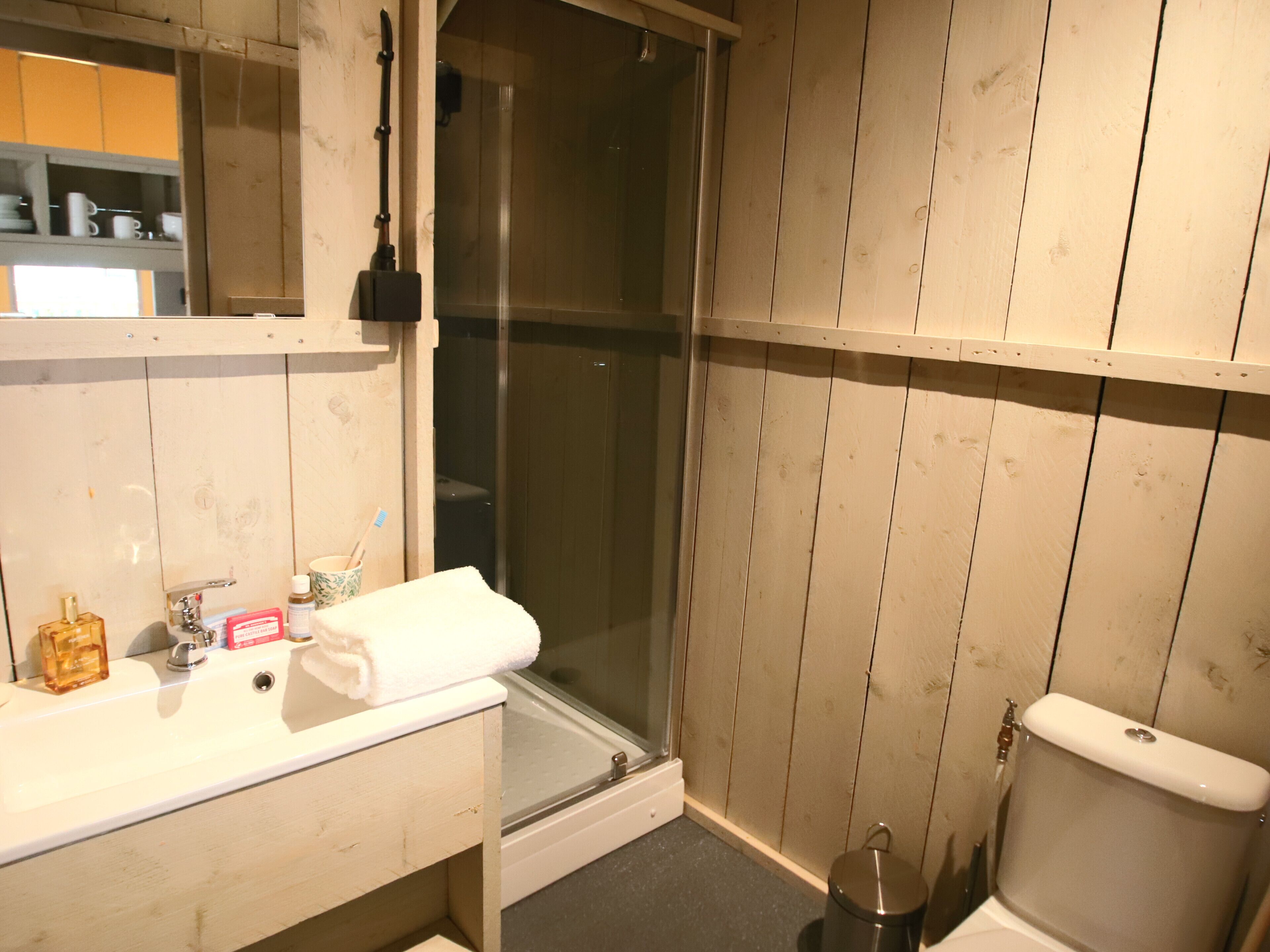 Ein Badezimmer mit Waschbecken, Duschkabine und Toilette.