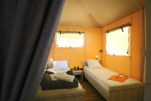 A compact room with two beds, a small table, and a window with curtains. - Truffe - Eco-lodge 3 - 7p (4) (Saint-Geniès)