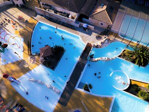 An aerial view of a swimming pool complex with multiple pools, a water slide, and lounge areas. - Palmyre - Privilège 3 - 6p (8) (Les Mathes)