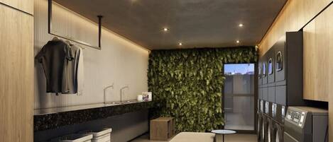 Una cocina moderna con una isla central, electrodomésticos integrados y una pared cubierta de follaje verde.