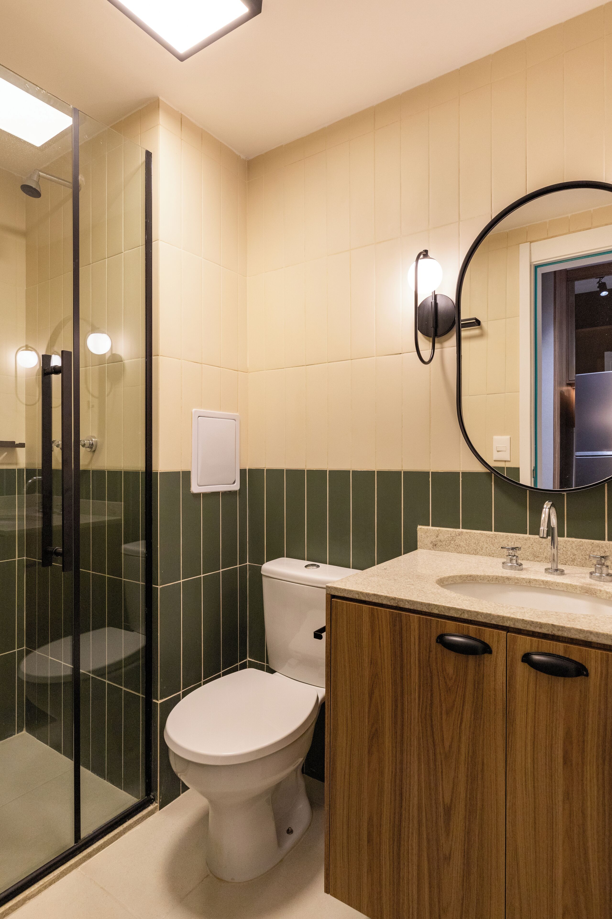 A modern bathroom with a glass shower enclosure, a toilet, a vanity with a sink, and a mirror.