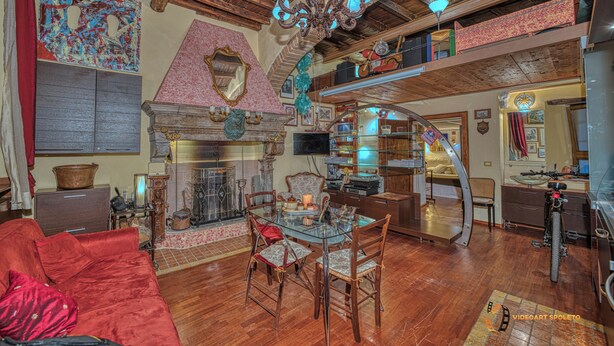 Un salón espacioso con chimenea, muebles de madera y un techo alto con vigas a la vista.