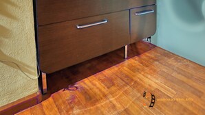 Un baño con tocador de madera, lavabo de vidrio y espejo arriba.