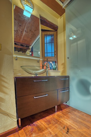 A bathroom with a wooden vanity, a glass sink, and a mirror above it. - GrandTourSuiteHome, Spoleto, romantic comfort apartment in historic center (SPOLETO)